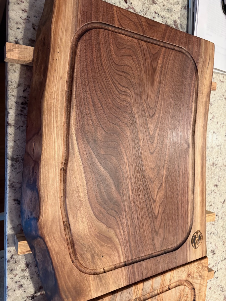 The Ridgeline — walnut carving board with juice groove on display stand
