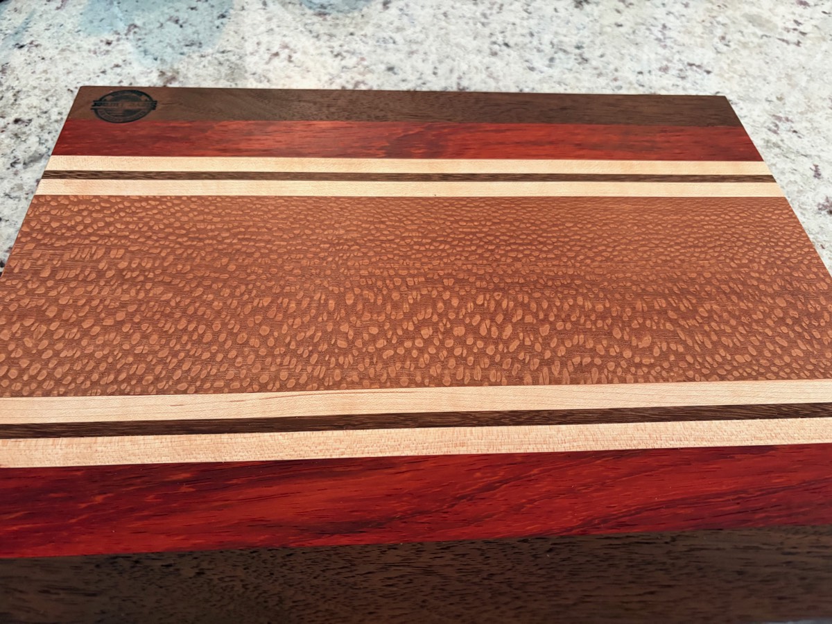 The Lacewood Reserve — lacewood, padauk, walnut cutting board with maple accents